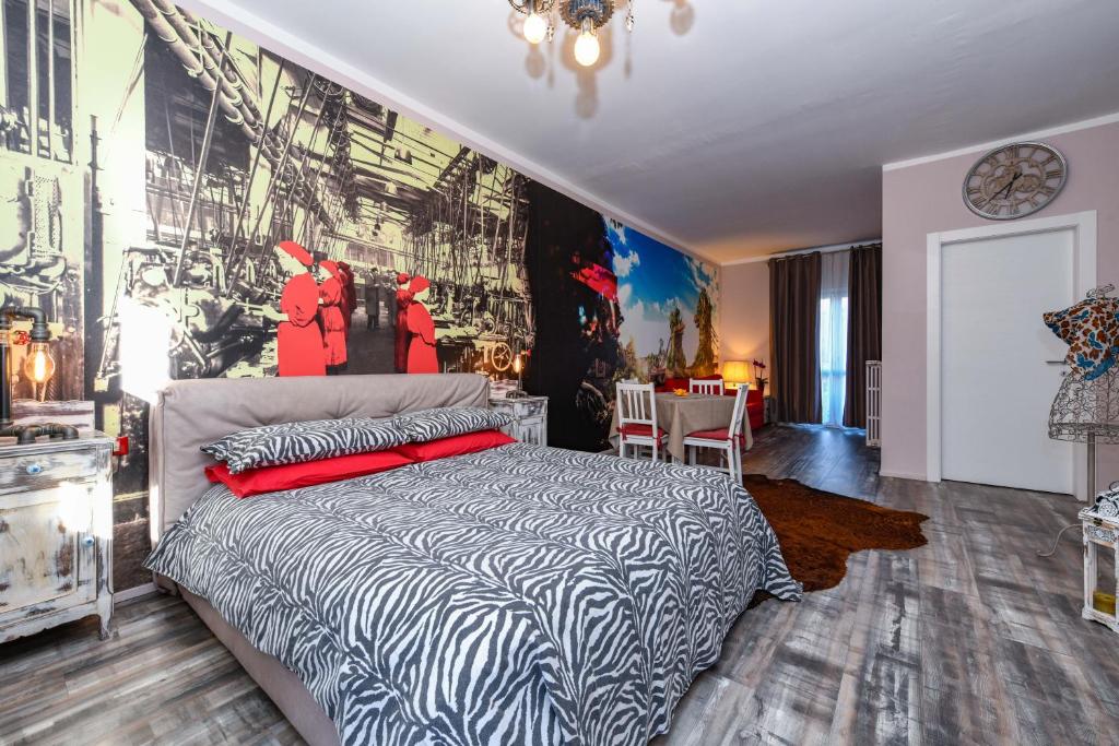 トスコラーノ・マデルノにあるVilla Giulia Rooms & Bikeのベッドルーム1室(ベッド1台付)が備わります。壁には絵画が飾られています。