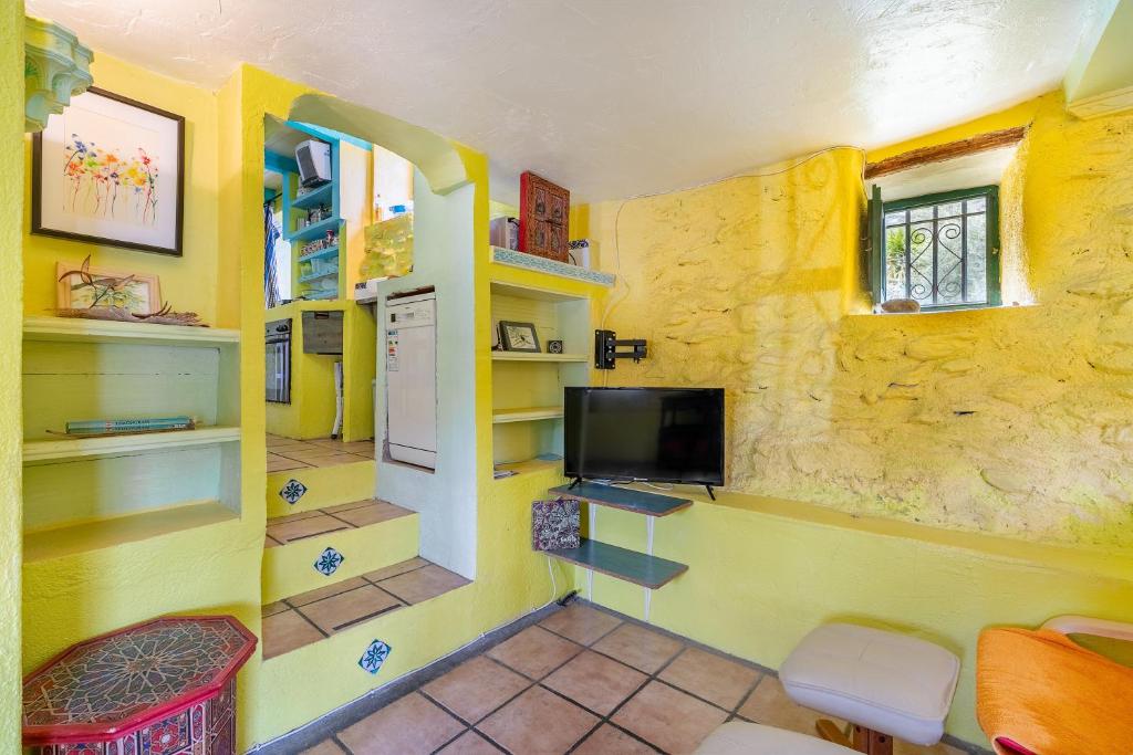 A television and/or entertainment centre at El Nido holiday cottage with pool