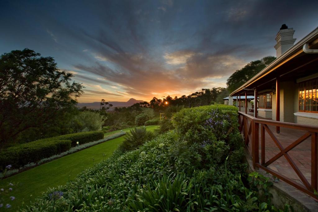 einen Sonnenuntergang über einem Haus mit Garten in der Unterkunft The Caledon Hotel and Spa in Caledon