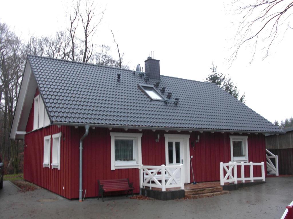 une maison rouge avec un toit rouge dans l'établissement Ferienwohnung Studiowohnung, offener Wohn- und Schlafber, à Langgöns