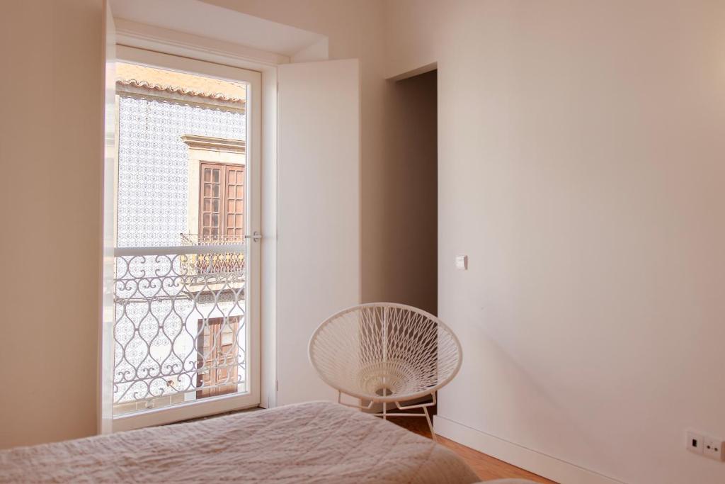 a bedroom with a fan and a window at Casa do Almirante in Tavira