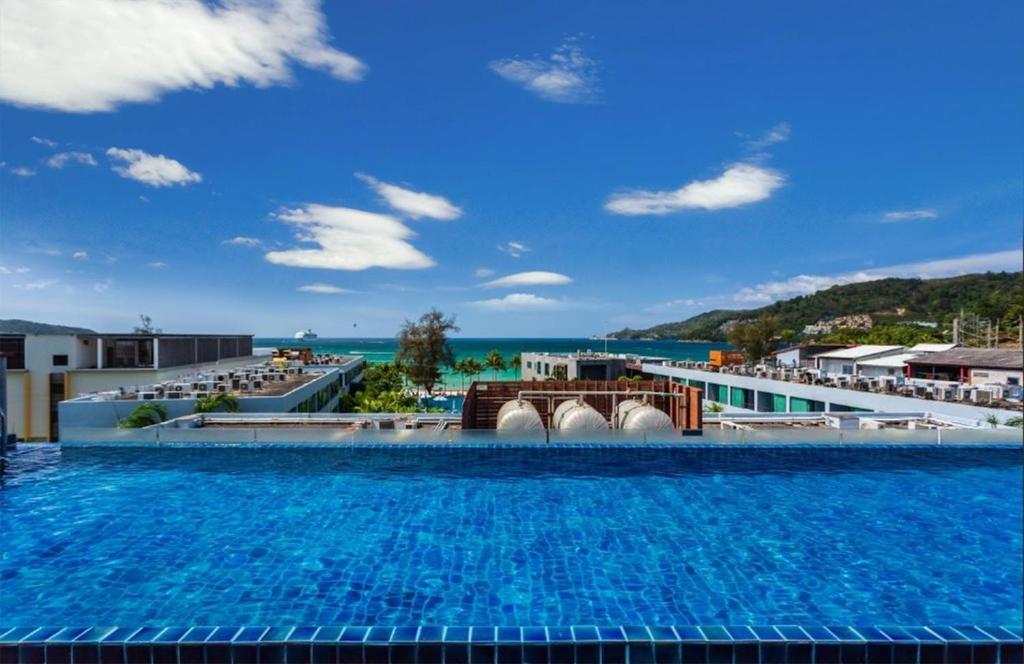 a large swimming pool with a view of the ocean at 7Q Patong Beach Hotel in Patong Beach