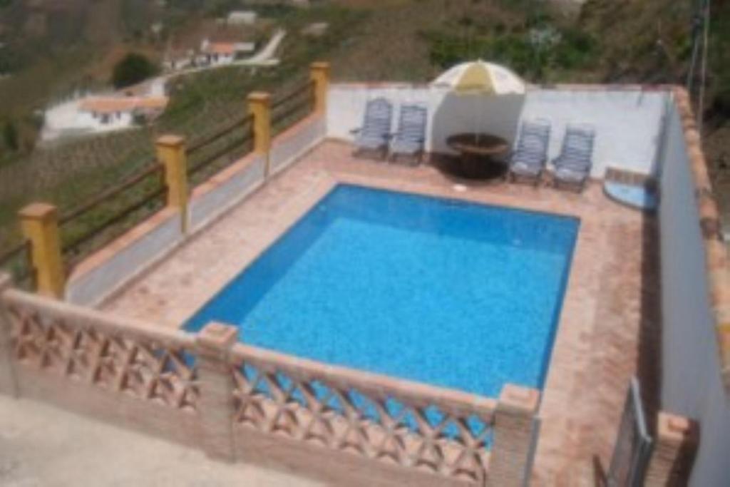 - une grande piscine avec des chaises et un parasol dans l'établissement House 6 Bedrooms with Pool and WiFi 8798, à Almáchar