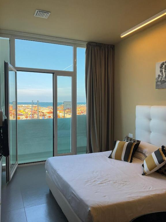 a bedroom with a large bed and a large window at Residence Terminus in Rimini