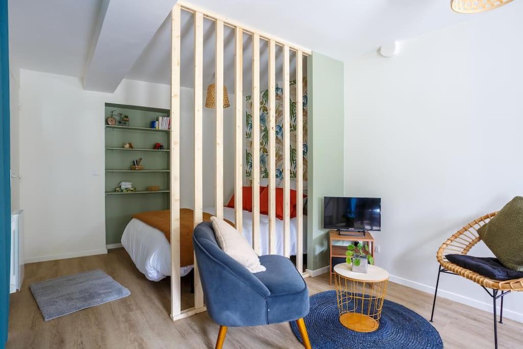 a living room with a crib and a blue chair at STUDIO COSY NEUF ORSAY - Proche ecoles et entreprises in Orsay