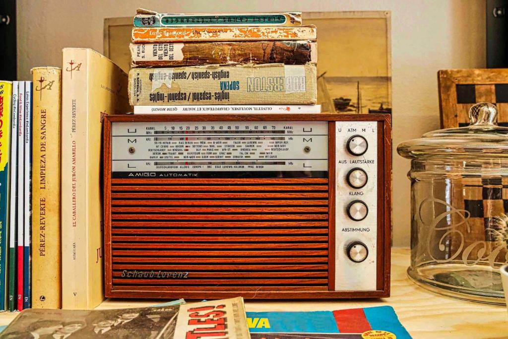 einen Stapel Bücher, die auf einem Radio sitzen in der Unterkunft Factory Hostels Barcelona in Barcelona