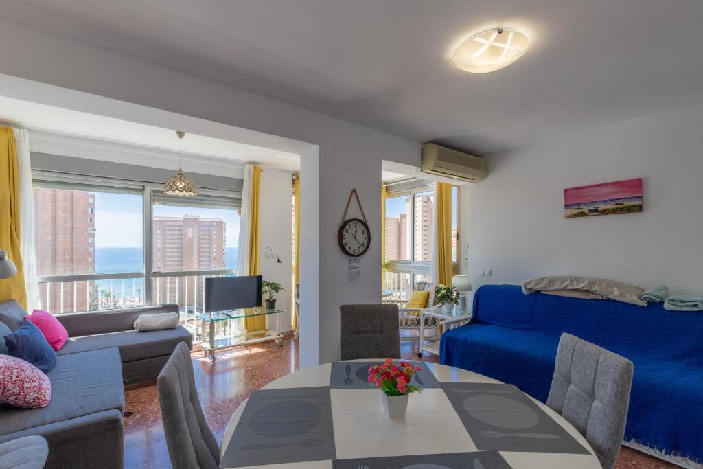 a living room with a blue couch and a table at Vistas Benidorm in Benidorm