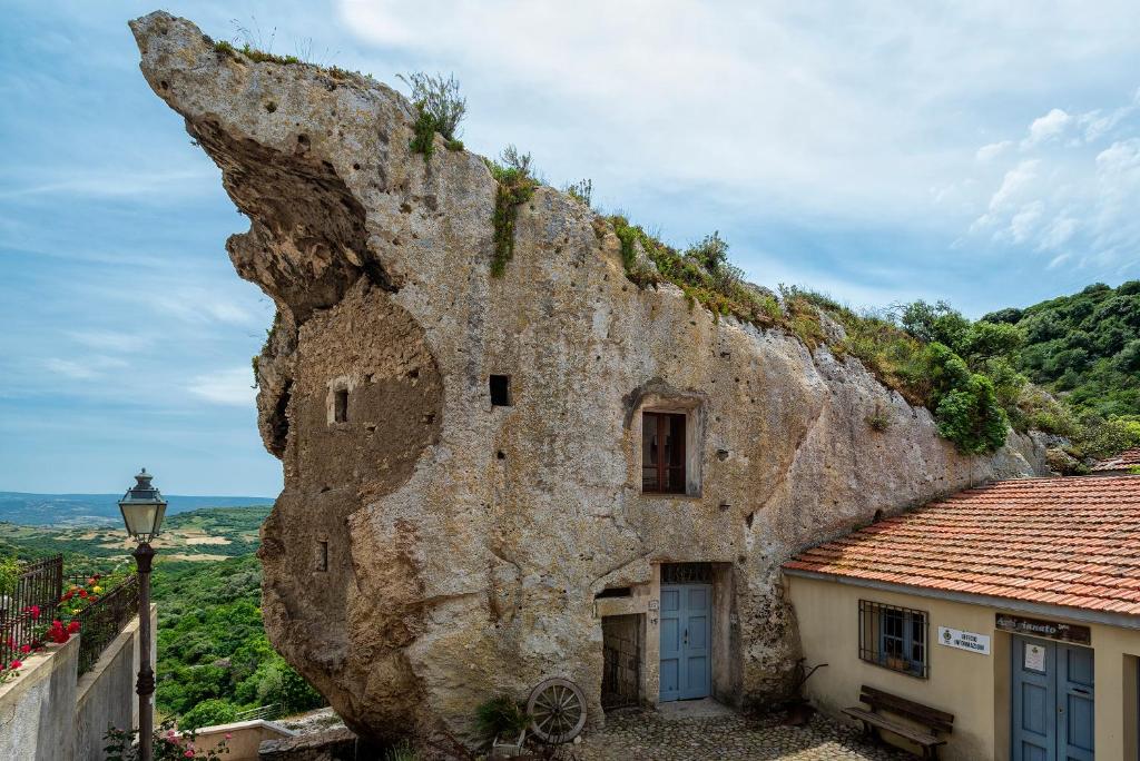una gran pared de piedra junto a un edificio en Domus Sedini vacanze al mare, en Sedini