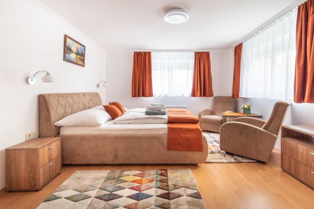 een slaapkamer met een bed en een woonkamer bij Topáz Apartmanházak Keszthely in Keszthely