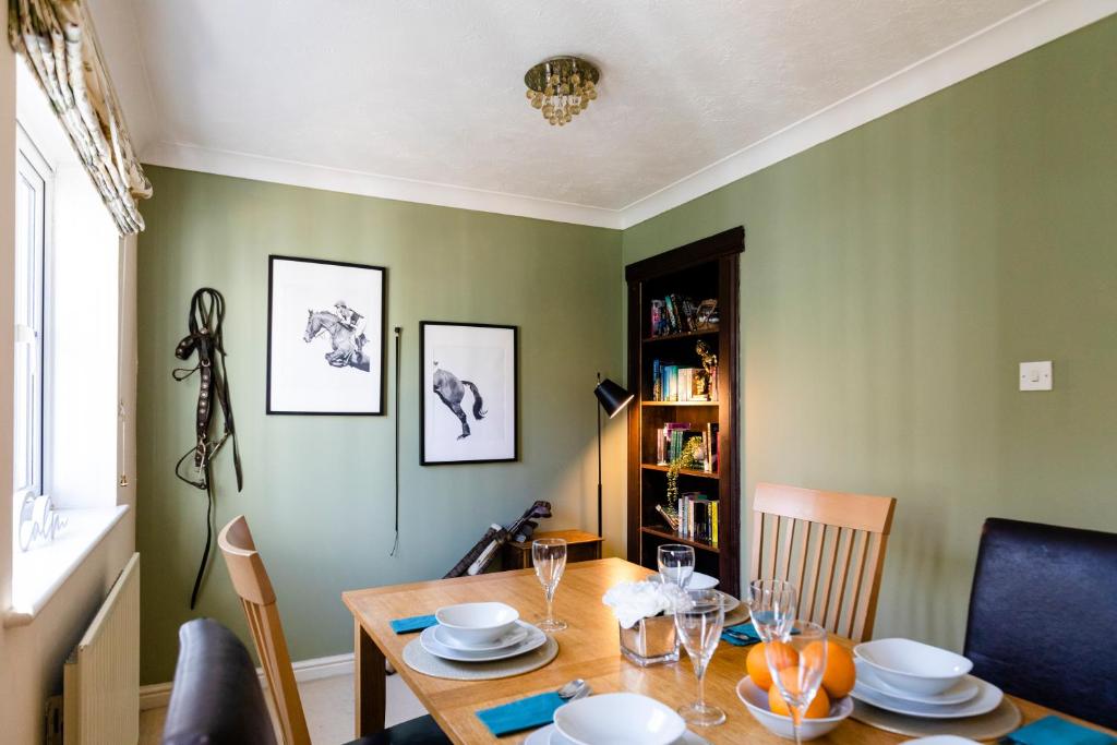 uma sala de jantar com uma mesa de madeira e cadeiras em Chichester retreat house with free parking em Chichester