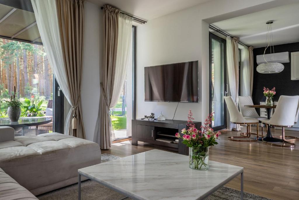 a living room with a couch and a table at Forest Cottage in Palanga