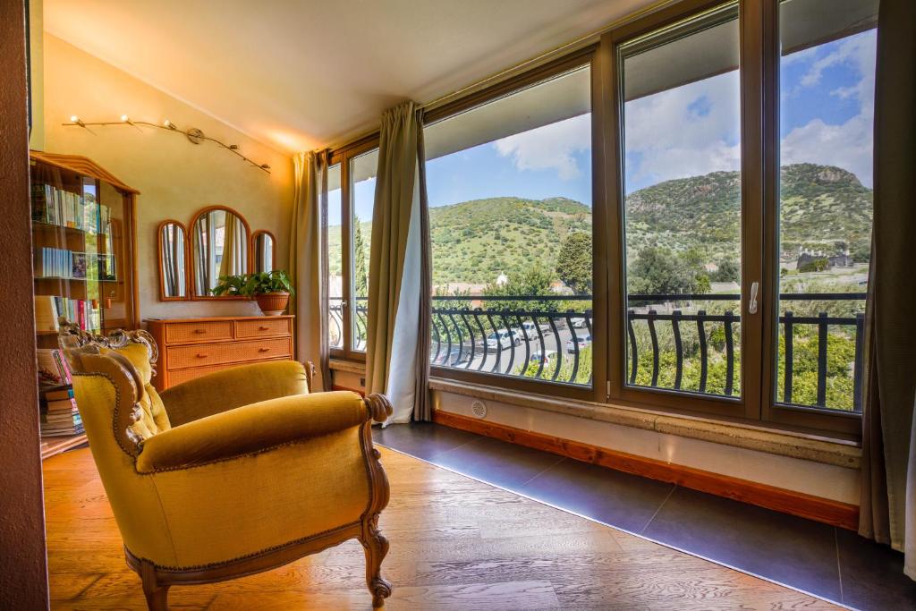 ボーザにあるSa Domo e Giuanne e Giuannaの椅子と景色を望む窓が備わる客室です。