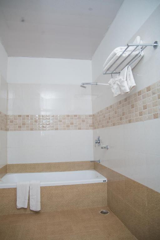 a bathroom with a bath tub with towels on it at Hotel Span in Butwāl