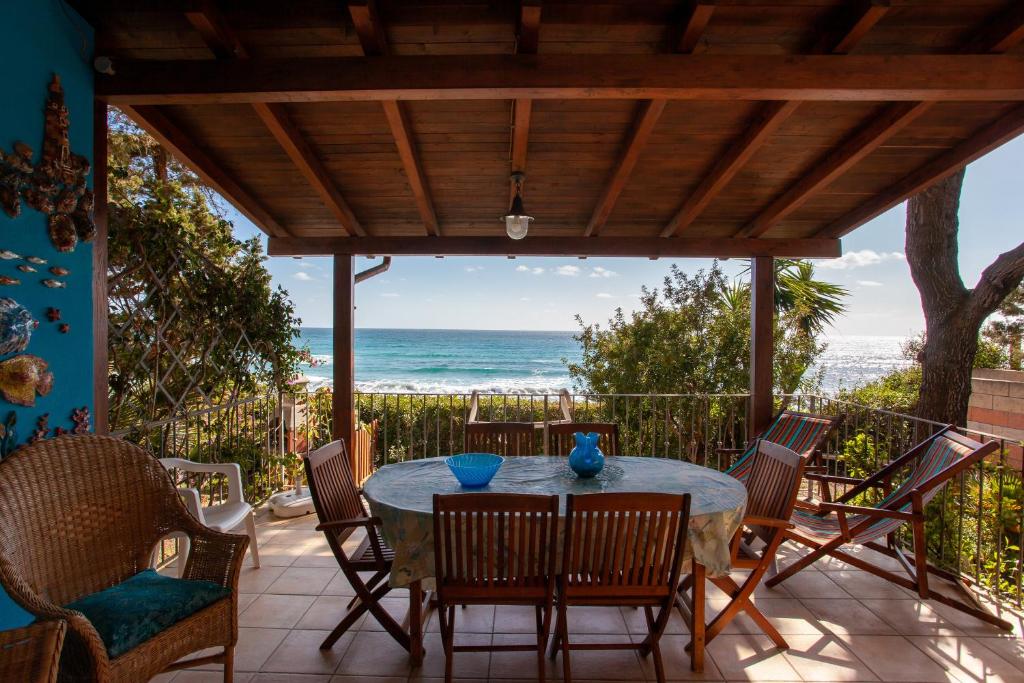 a patio with a table and chairs and the ocean at casa sulla spiaggia 2 in Orosei