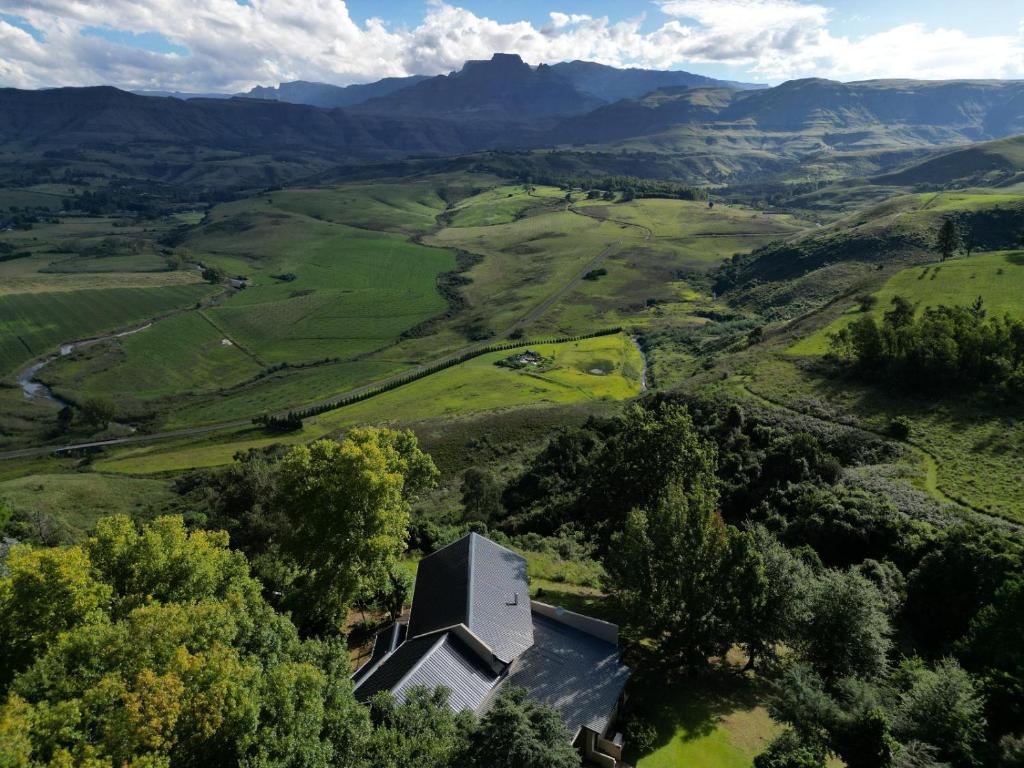 - une vue aérienne sur une maison dans une vallée avec des montagnes dans l'établissement Drakenzicht Mountain Cottage, à Winterton