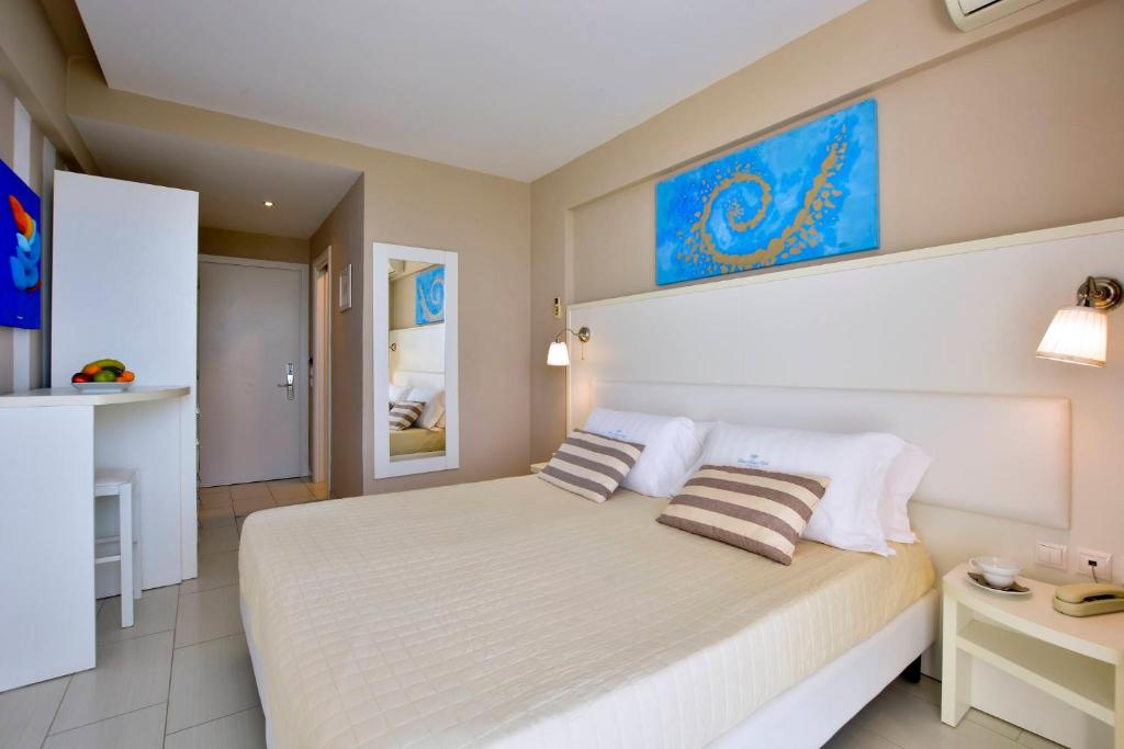 una camera da letto con un grande letto bianco con due cuscini di Sidari Beach Hotel a Sidari