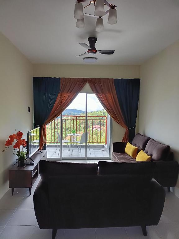a living room with a couch and a large window at Alyaleesya Emerald avenue 4 Brinchang for muslim in Brinchang