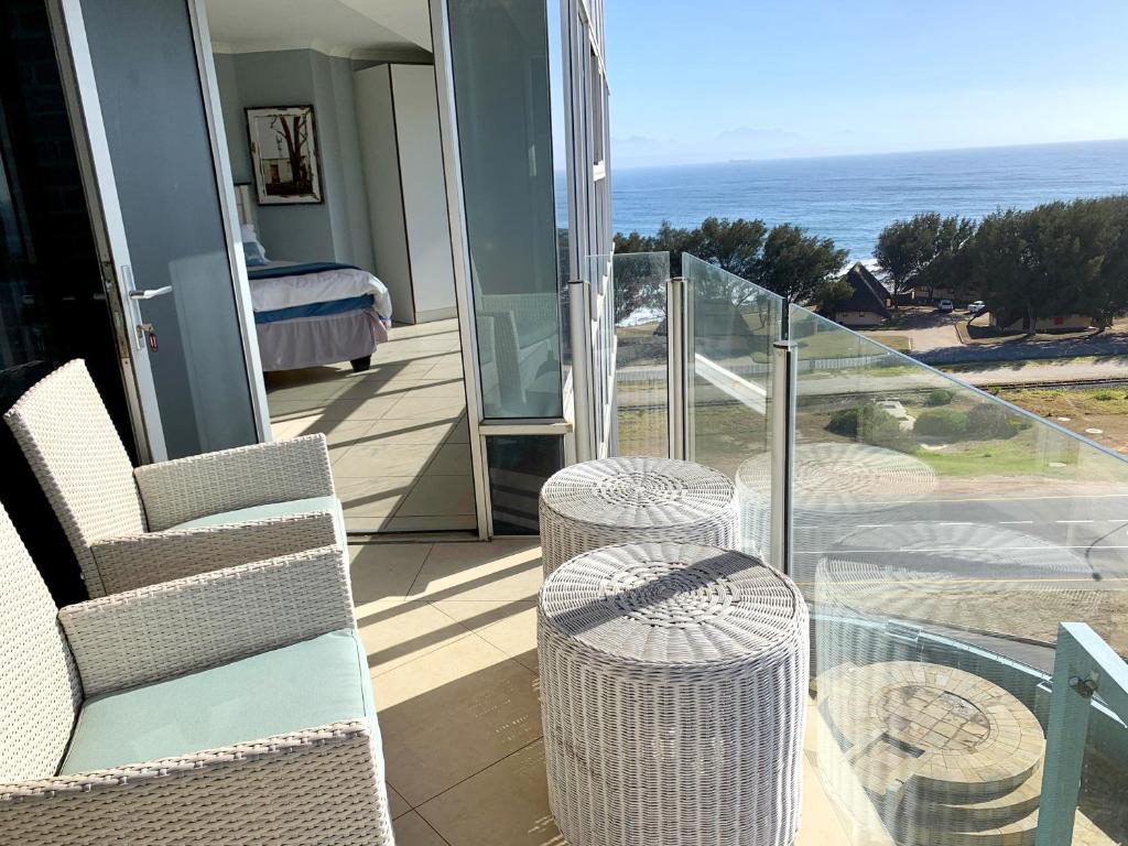 einen Balkon mit Blick auf ein Bett und das Meer in der Unterkunft Spacious 2 bedroom space with breathtaking seaview in Mossel Bay