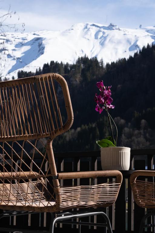 a bench and a flower in a vase on a balcony at Hotel Central in Engelberg