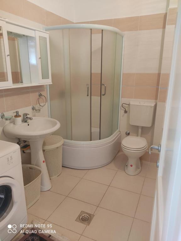 y baño con ducha, aseo y lavamanos. en Jovana -- porodicni apartmani Igalo, en Herceg-Novi