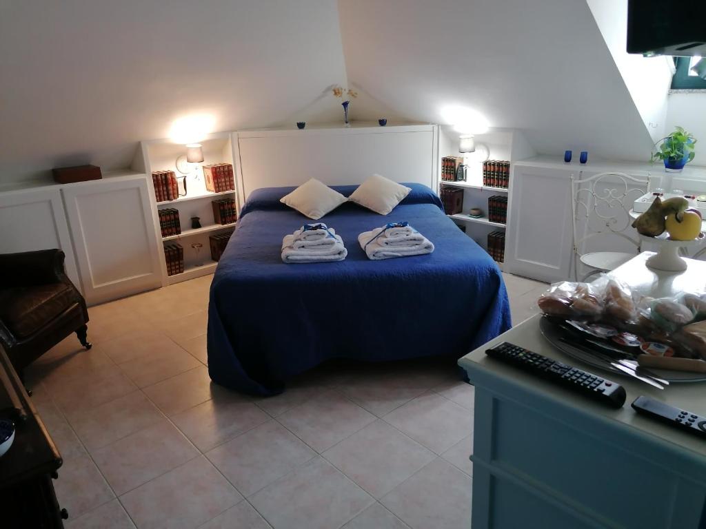 1 dormitorio con cama con sábanas azules y escritorio en Coros, en Nuoro