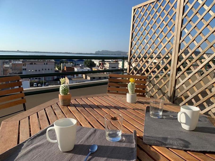 drewniany taras ze stołem i krzesłami na balkonie w obiekcie Panoramic Sport Apartment: vista golfo di Cagliari w Cagliari