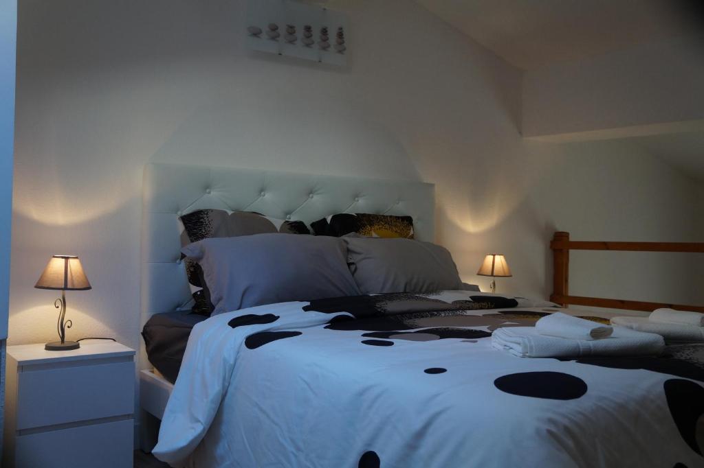 una camera da letto con un grande letto con pois neri di Appartements Victor et Hugo a Bordeaux