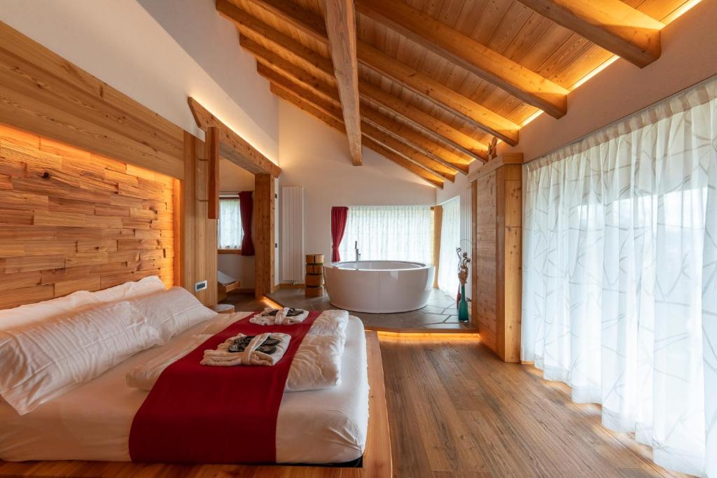 una camera con un grande letto e una vasca da bagno di Casera Degnona a Chies dʼAlpago