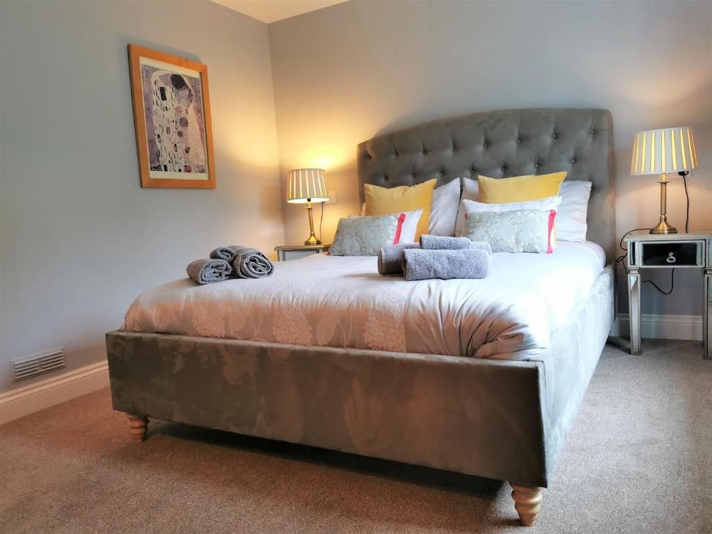 a large bed in a bedroom with two lamps at Romantic Cottage with Private Hot Tub in Llanfyrnach