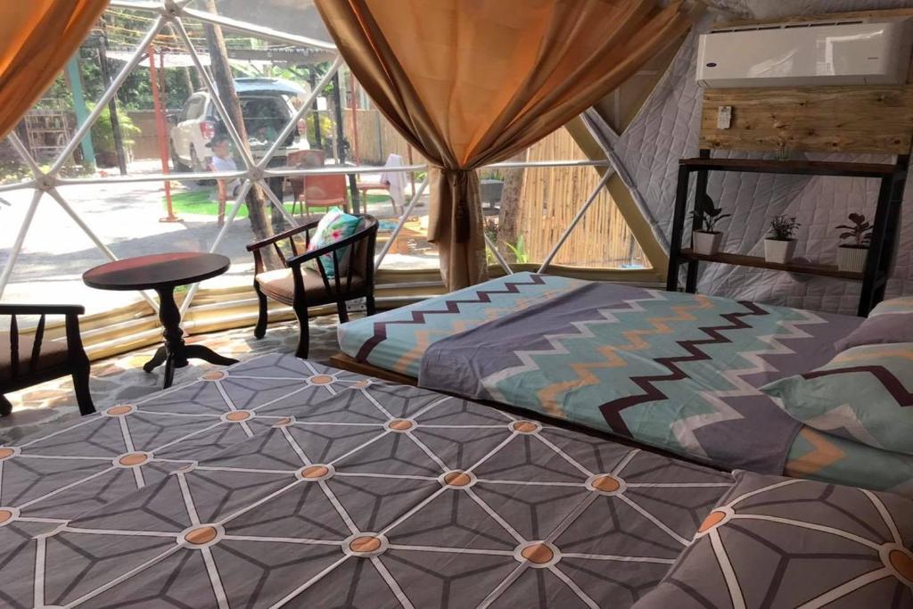 two beds in a room with a window at Liwa-Liw Beach Villas & Dome Glamping in San Felipe