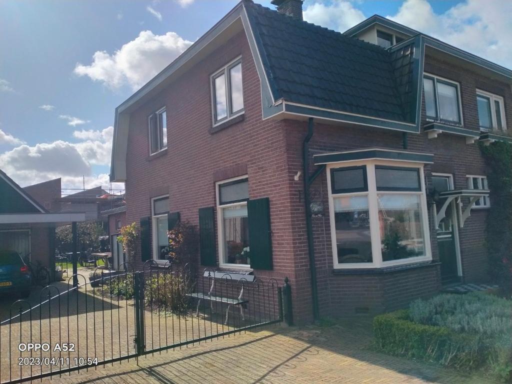 a brown brick house with a black roof at De Grindweg in Holten