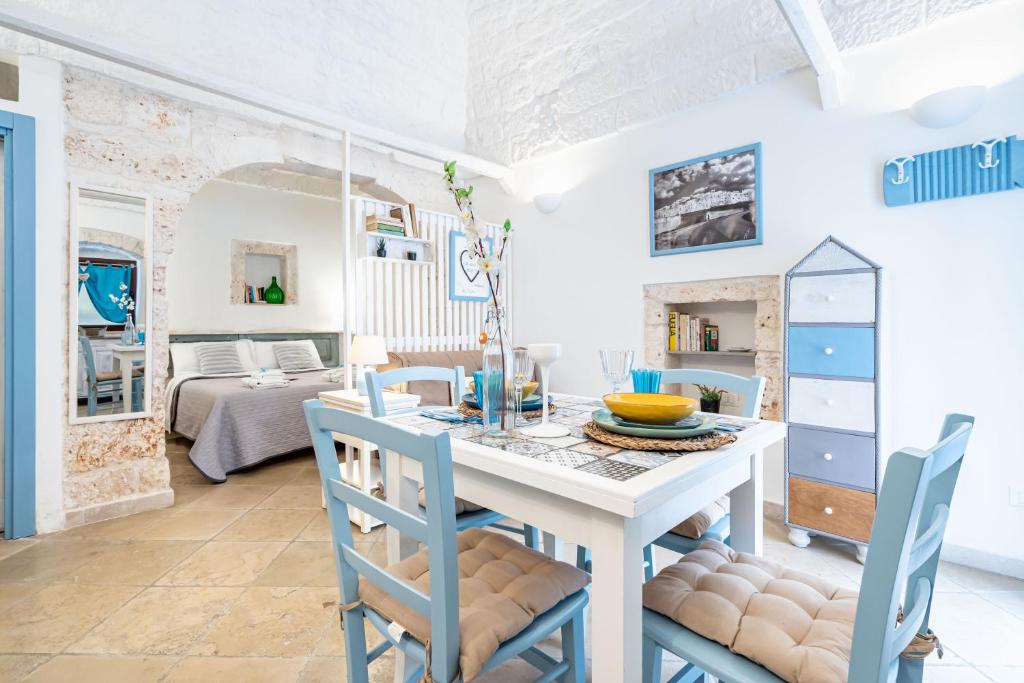 a dining room with a white table and chairs at Vico di Ostuni Apartments by Rentbeat in Ostuni