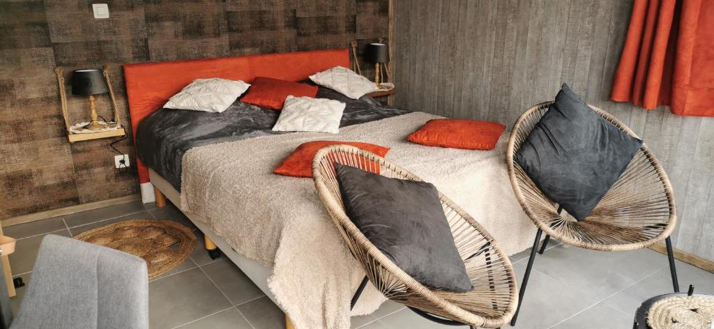 a bedroom with a bed with two chairs at temps 1solite in Andenne