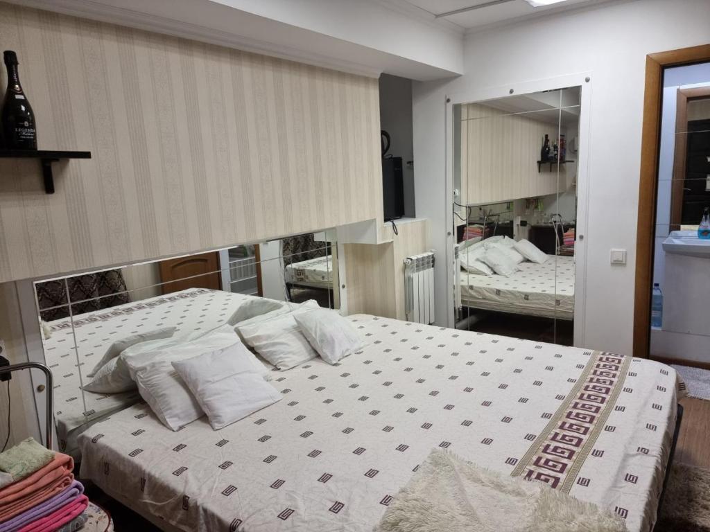 a bedroom with a bed with white sheets and pillows at Good choise in Chişinău