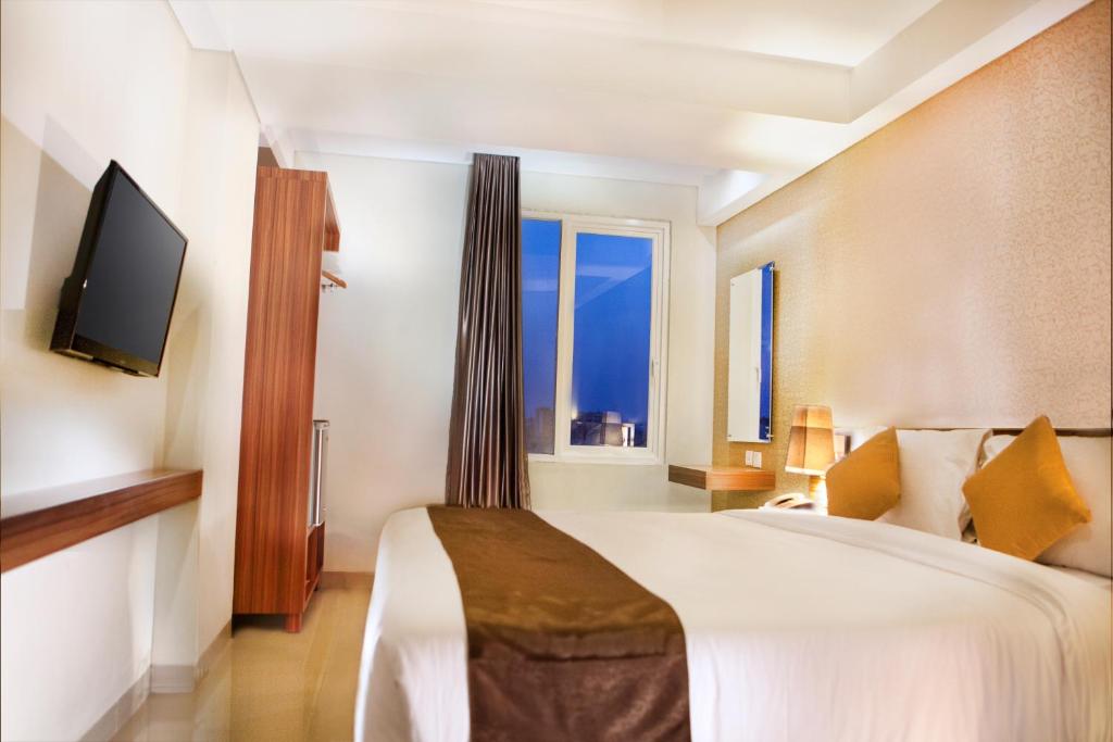 a hotel room with a bed and a television at H Boutique Hotel Jogjakarta in Yogyakarta