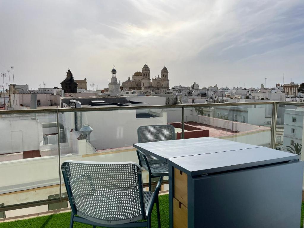 uma mesa e cadeiras numa varanda com vista para a cidade em Skyline - Loft with private terrace and breathtaking views! em Cádiz