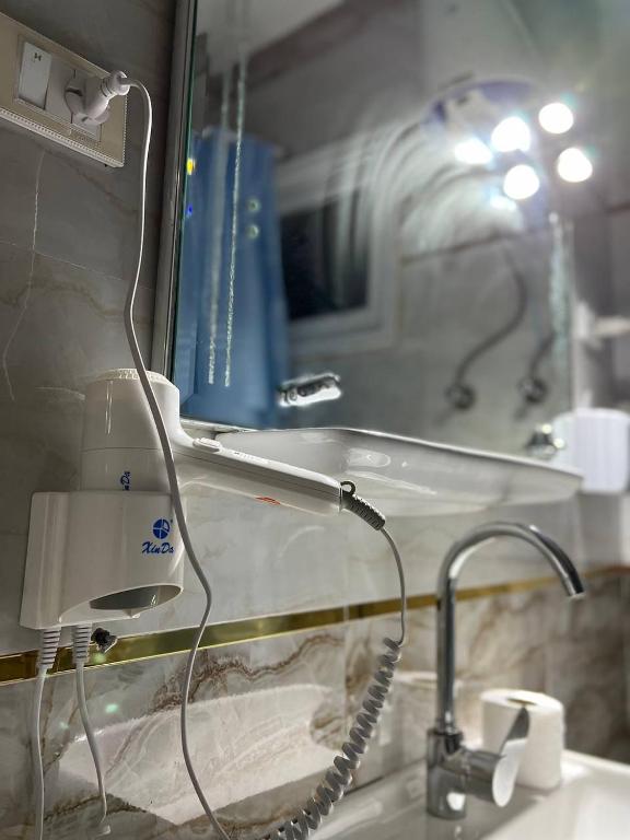 un lavandino in bagno con asciugacapelli accanto a uno specchio di Lucky Hostel a Il Cairo
