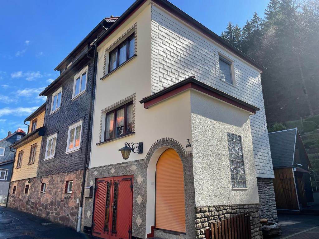 a house with a red door and a building at Ferienwohnung Beer in Fehrenbach