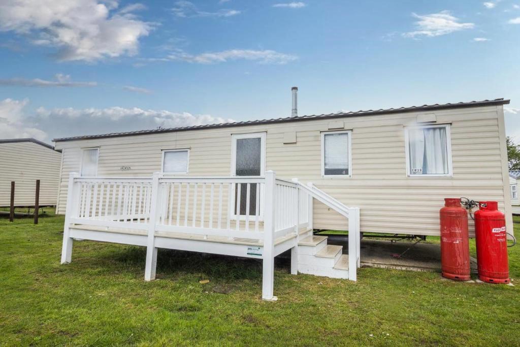 a white house with two red fire hydrants in front of it at 3 Bed, 8 Berth Caravan For Hire At St Osyth Park Near Clacton-on-sea Ref 28039cw in Clacton-on-Sea