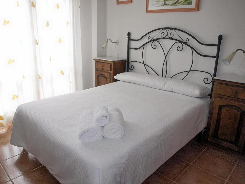 una camera da letto con un letto e due asciugamani di Apartamento Alameda Ezcaray, piscina y ascensor a Ezcaray