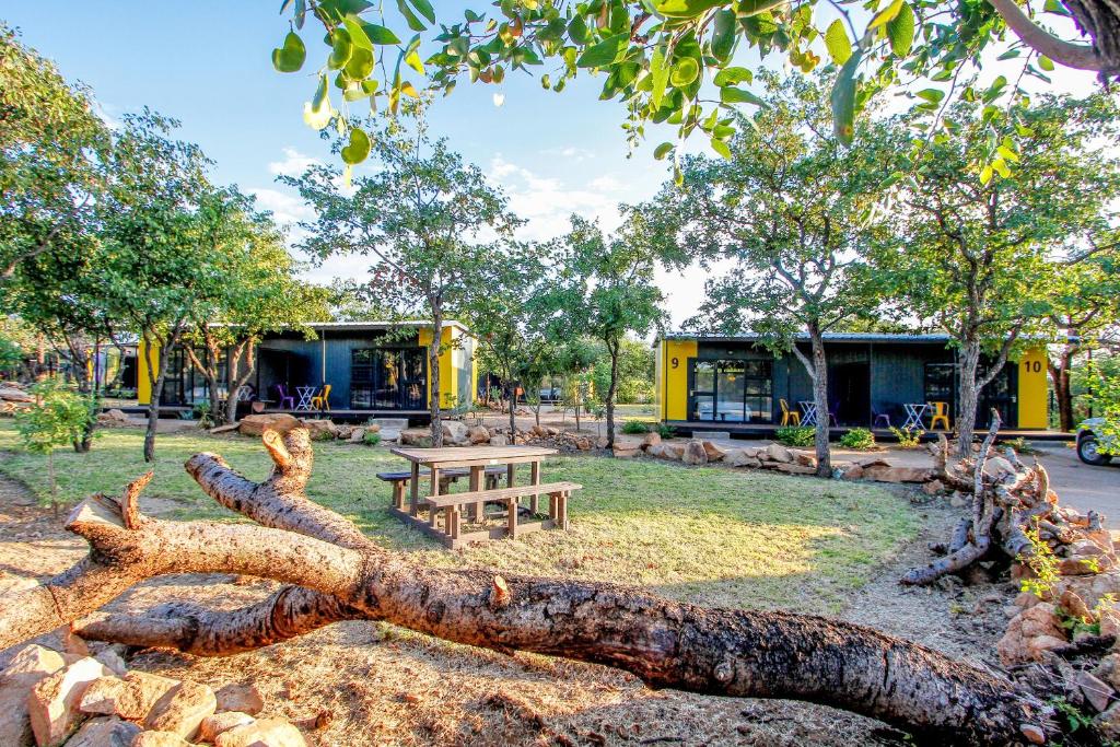 a tree branch laying on the ground next to a picnic table at SleepOver Orpen Gate in Acornhoek