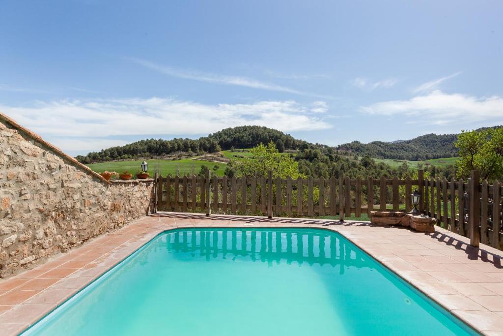 una piscina en un patio con una valla de madera en El Mas de Tous en San Martín de Tous