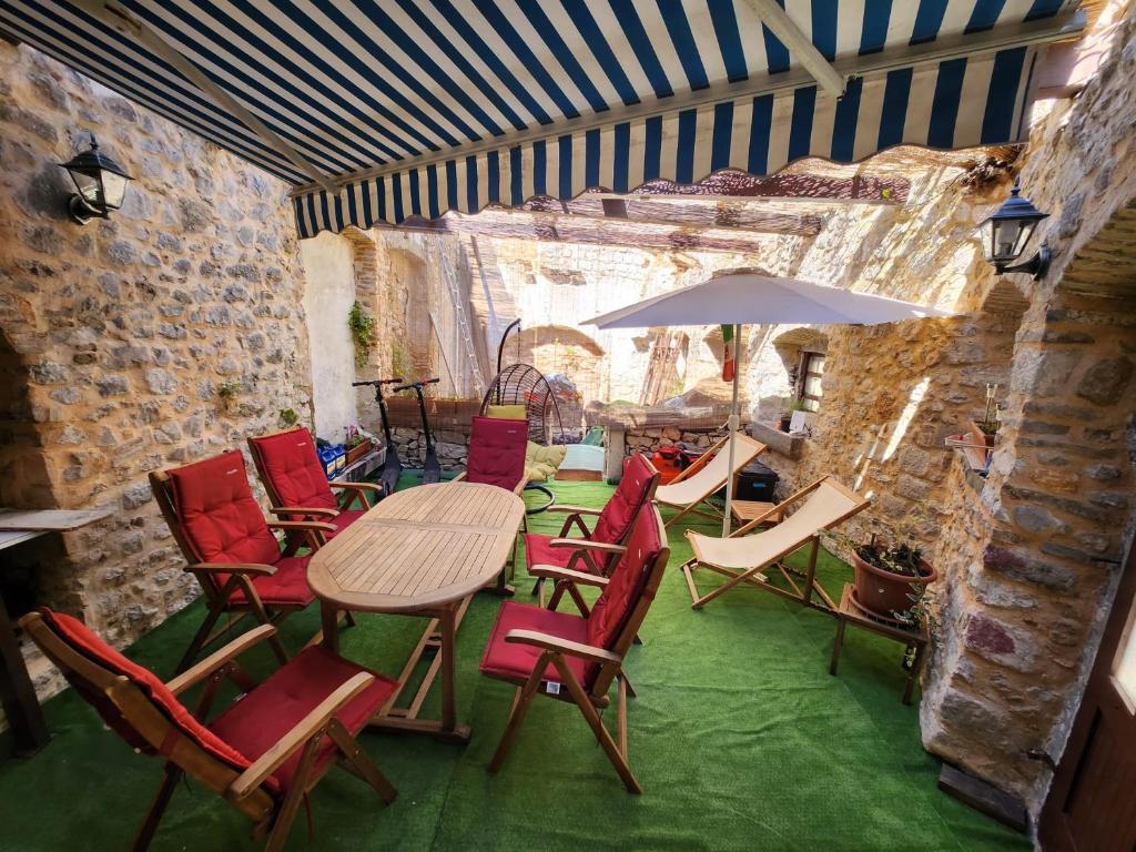 ein Zimmer mit einem Tisch, Stühlen und einem Sonnenschirm in der Unterkunft Lovely holiday home in Cres