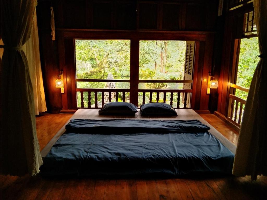 uma cama grande num quarto com uma janela grande em Mận Homestay - Lục Yên Homestay and Tour 