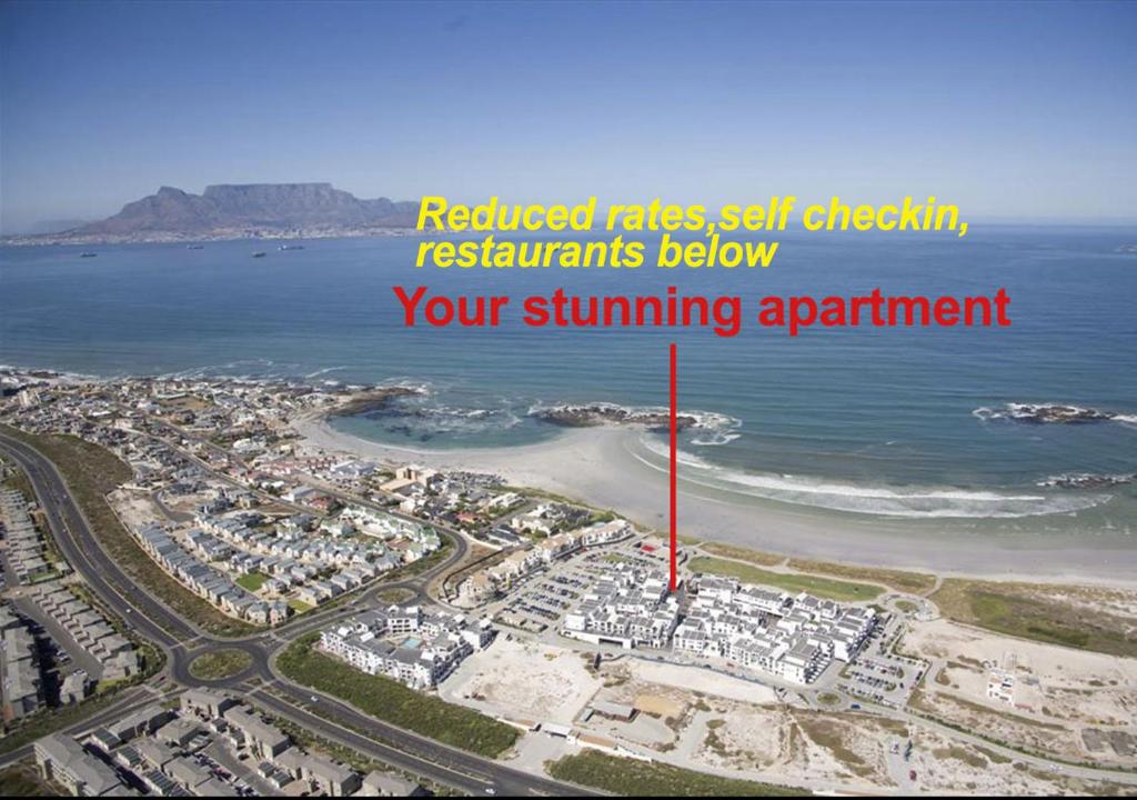 ariel view of a beach with a red arrow at A Modern unit, self checkin, restaurants and shops below in Cape Town