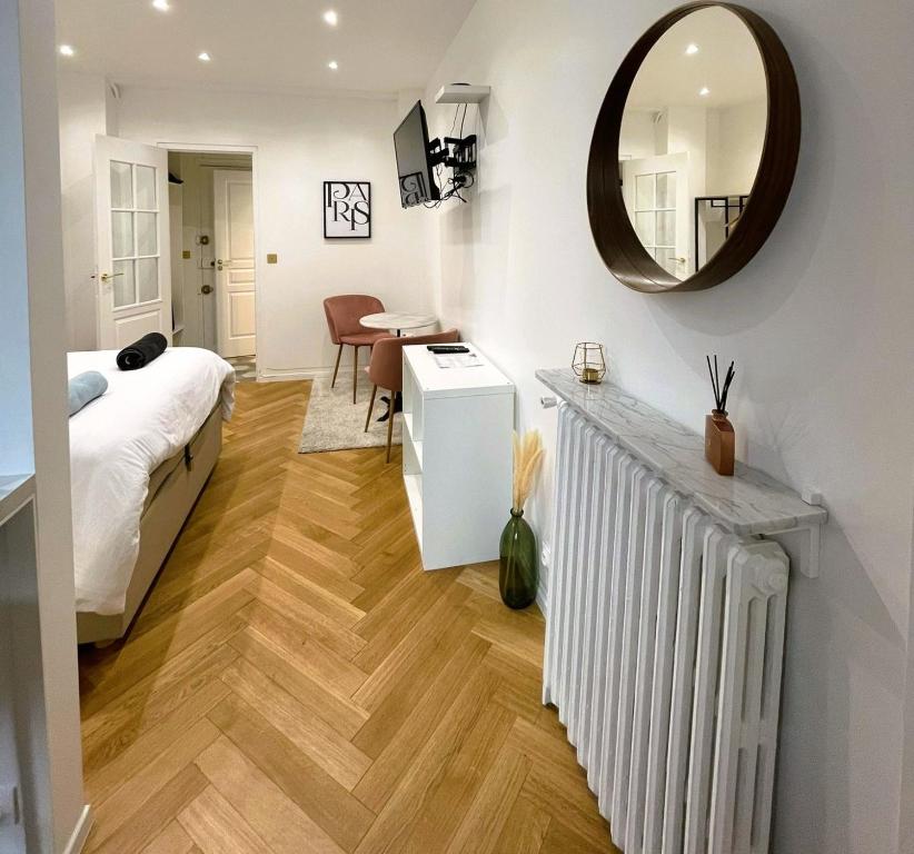 - une chambre avec un lit et un miroir dans l'établissement Appartement Vincennes proche métro 15 minutes Marais, à Vincennes