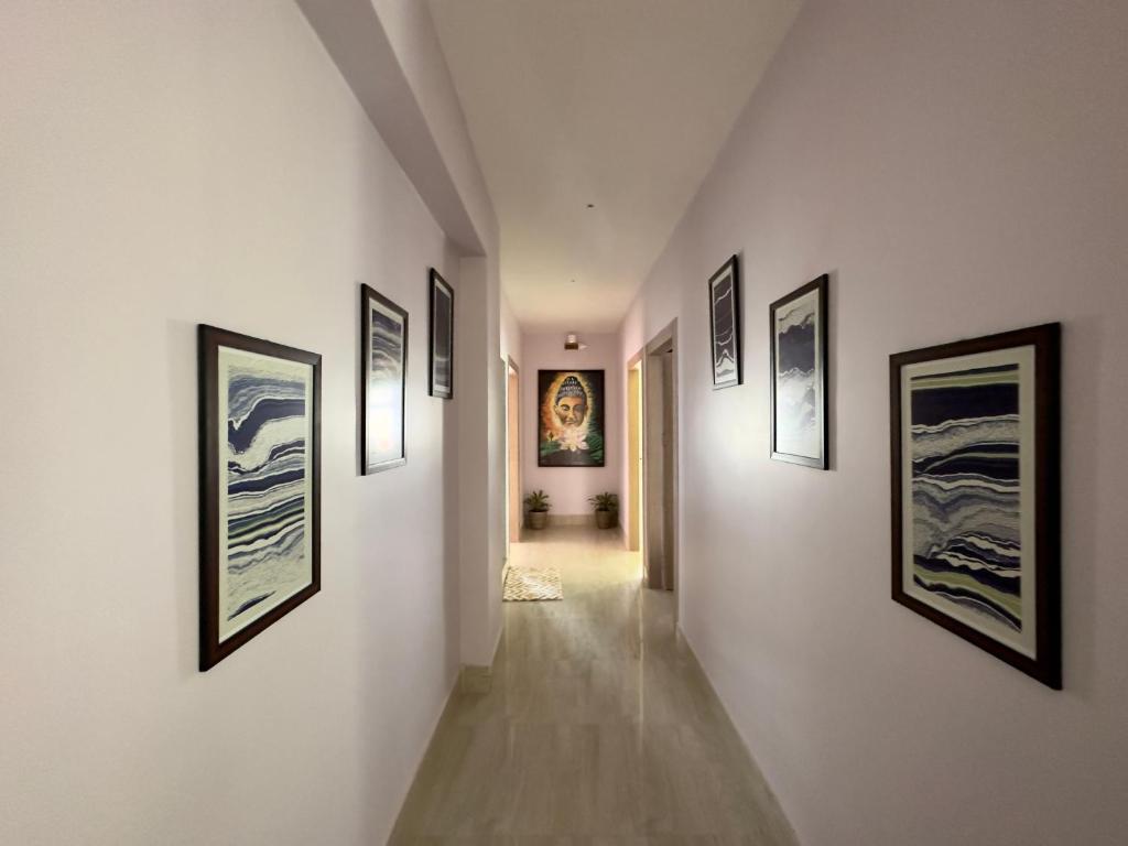 a hallway with framed pictures on the walls at Three Little Birds Homestay in Guwahati