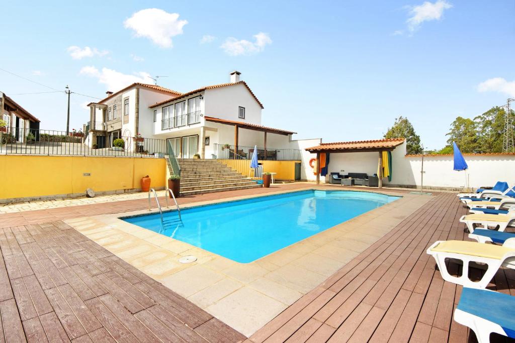 - une piscine avec des chaises et une maison dans l'établissement Casa de Barqueiros, à Barqueiros