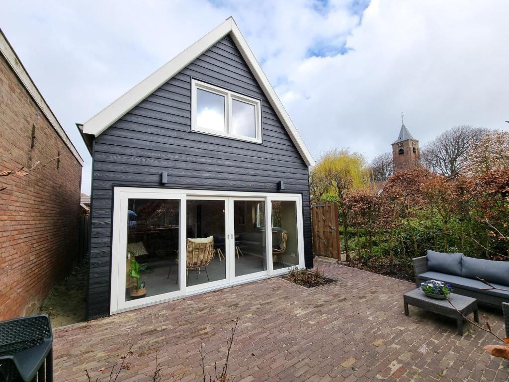 a house with a large sliding glass door at Vakantiehuis Aagtekerke AK12 in Aagtekerke