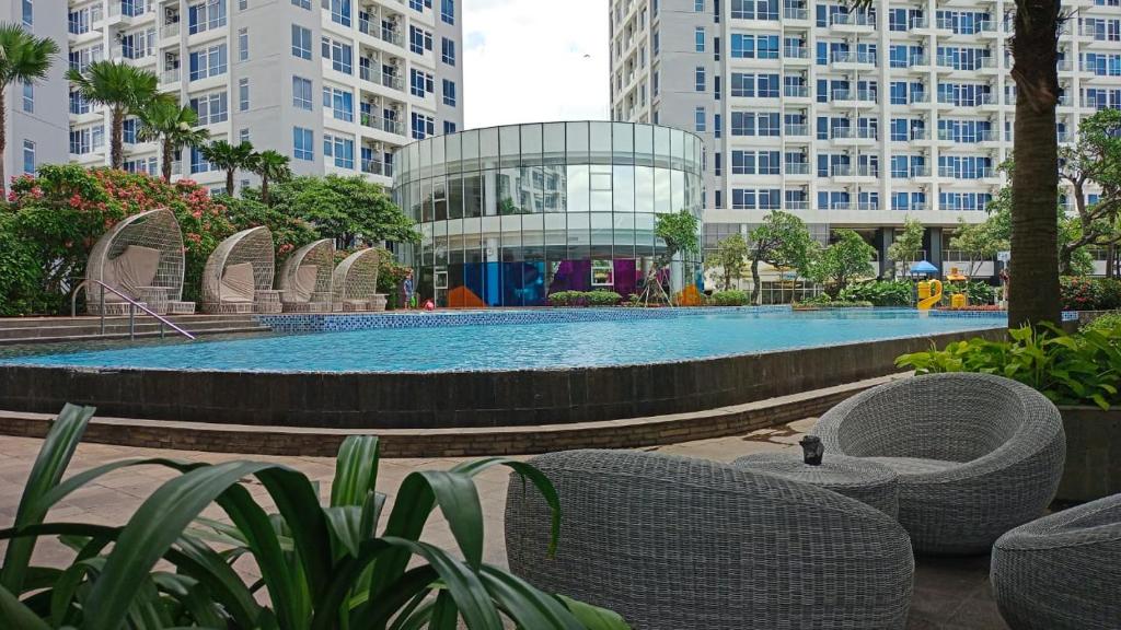 une grande piscine dans une ville avec des bâtiments dans l'établissement Iproperti, à Jakarta